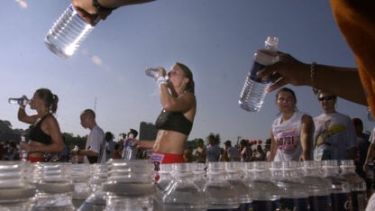 A person hands out bottled water during a race