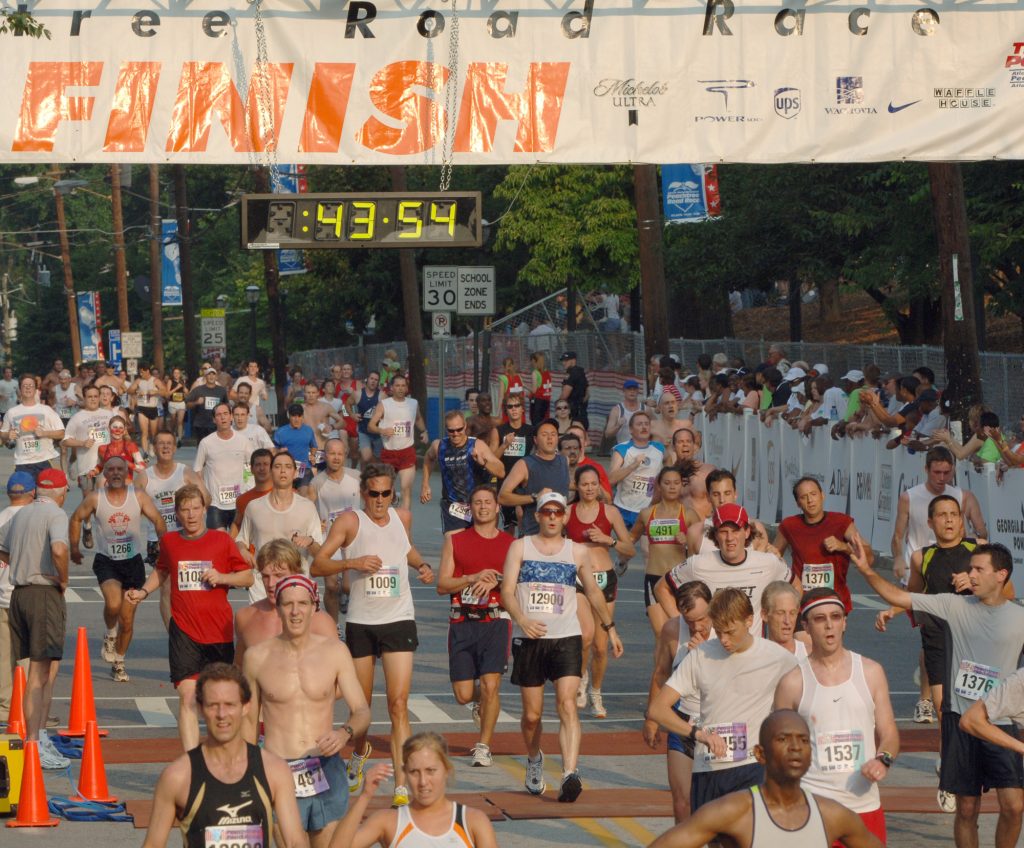 Runners cross the finish line as they participate during the Peachtree Road Race, Tuesday, July 4, 2006, in Atlanta. (AP Photo/Gregory Smith)