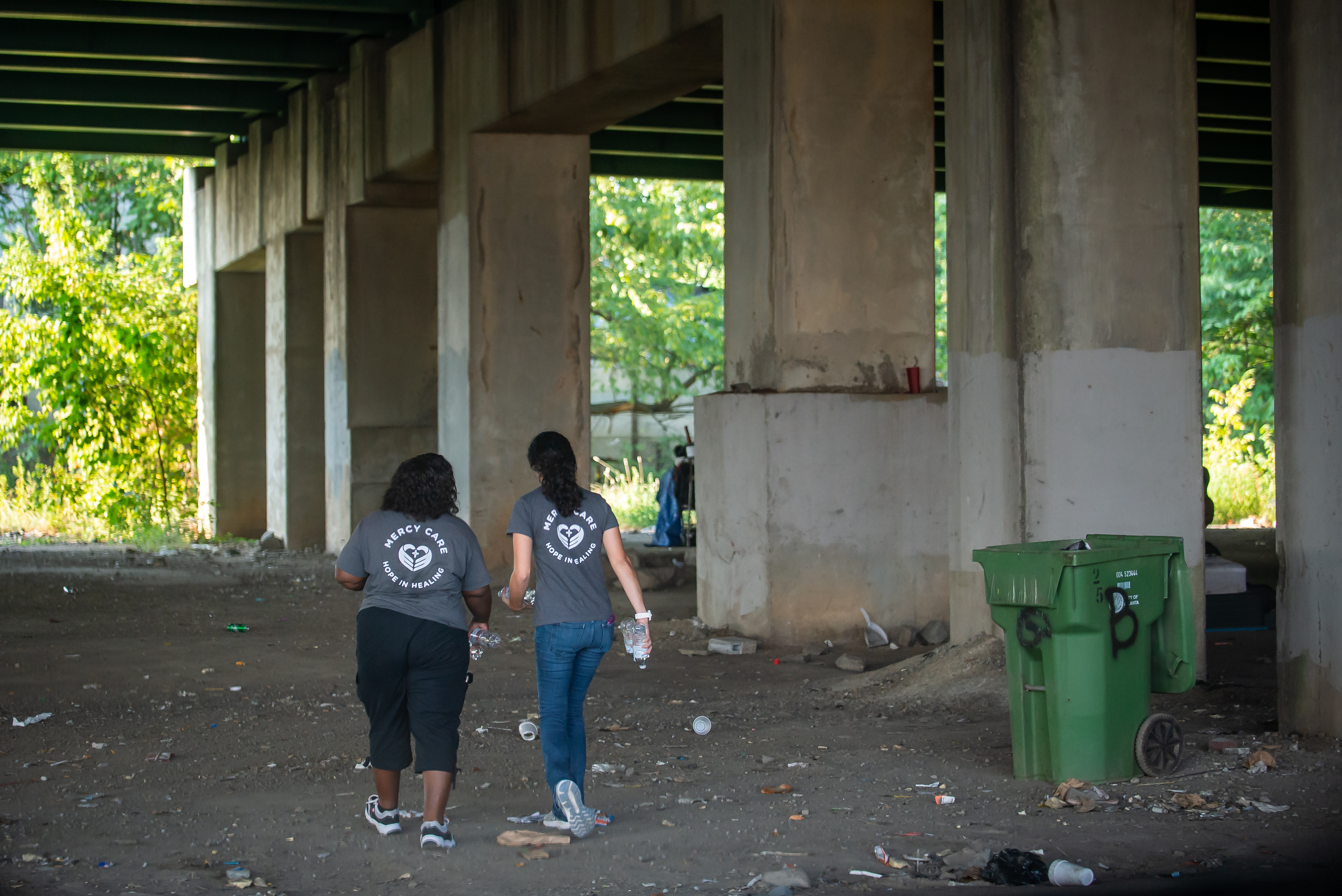 090919 ATLANTA Ð (From left) Stephanie Dotson, a licensed practical nurse, and Joy Fernandez de Narayan, a nurse practitioner, walk under an I-20 bridge in downtown Atlanta after bringing water and checking on people living in tents in the shade of the underpass on Monday, Sept. 9, 2019. Dotson and Fernandez de Narayan are part of the Mercy Care Street Medicine team, and work to provide medical and behavioral health care to the cityÕs homeless population. PHOTO BY BITA HONARVAR