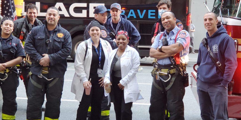 Brandy Brown, center right, and a colleague are sent off to work in New York by a group of New York City firemen. She's spent the last three weeks working in the midst of the crisis there.
