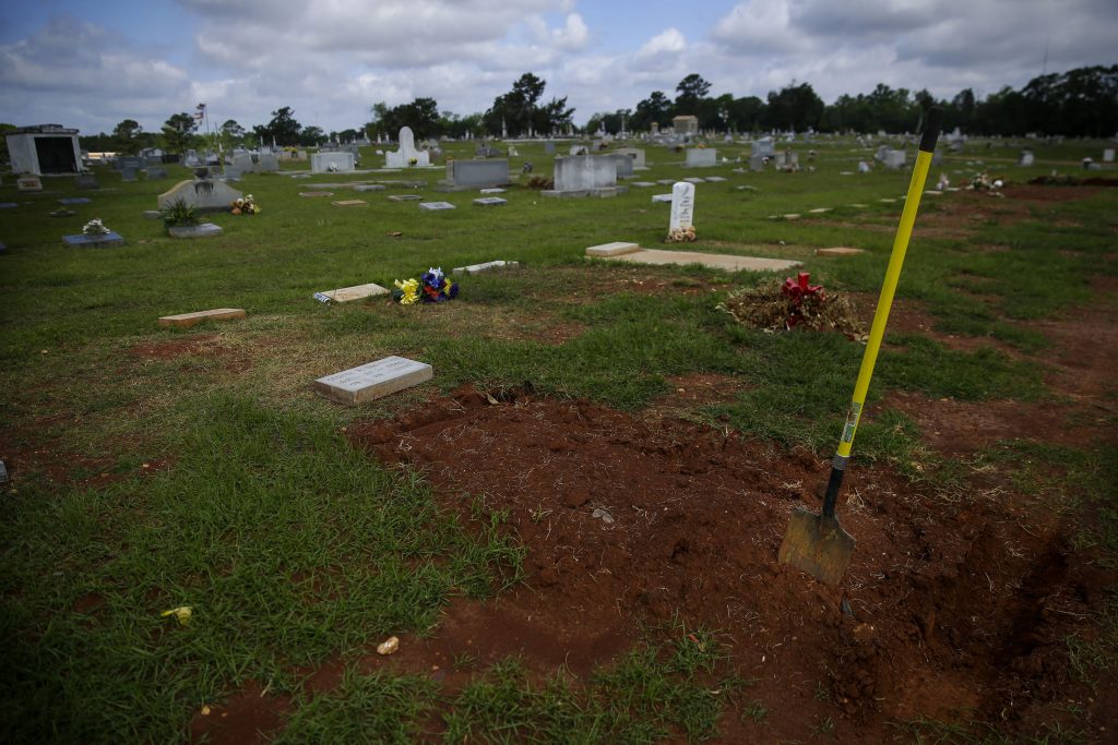 A shovel sits in a freshly-covered grave at the Cedar Hill Cemetery on Saturday, April 18, 2020, in Dawson, Georgia.