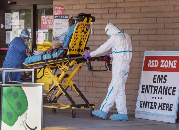 A patient is taken from an ambulance to the emergency room of a hospital in the Navajo Nation town of Tuba City, Ariz., on May 24. Weeks of delays in delivering vital coronavirus aid to Native American tribes exacerbated the outbreak, according to Navajo Nation President Jonathan Nez. Photo Credit: Mark Ralton/AFP via Getty Images