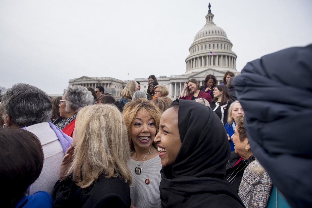 Rep. Lucy McBath, D-Ga., center, smiles with Rep. Ilhan Omar, D-Minn., second from right, 