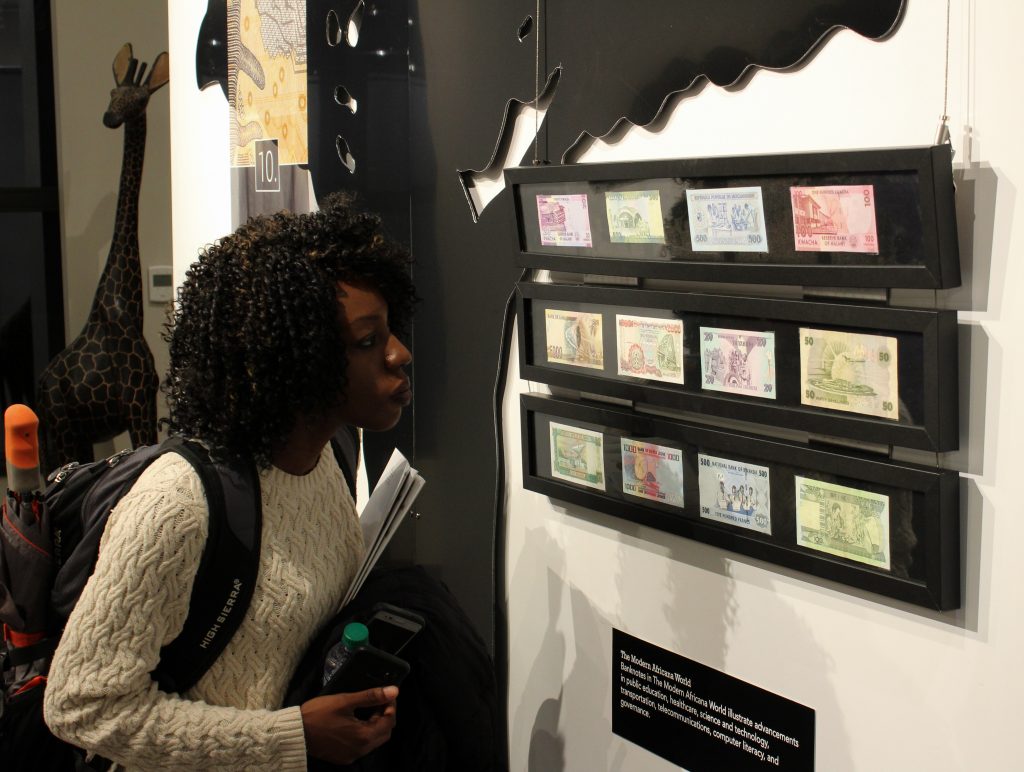A Georgia State University student takes a closer look at the currency at the Auburn Avenue Research Library. (Ruben Lebron)