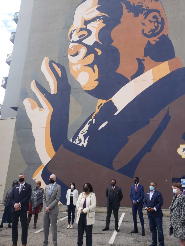 “Standing under this mural of this celebrated hero, we will not compromise our fundamental view that this is about ending a racist policy designed to systematically exclude Black people and others from our democracy,” said Rep. Josh McLaurin, D-Sandy Springs, near the painting depicting John Lewis. (Christopher Alston/WABE)
