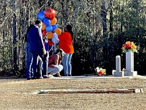In this Feb. 23 photo, Wanda Cooper-Jones kneels before the grave of her son, Ahmaud Arbery, at the New Springfield Baptist Church in Waynesboro to mark the one year anniversary of Ahmaud Arbery's death in Brunswick. The Justice Department announced federal hate crime charges Wednesday in the death of Arbery, who was killed while out for a run. (Lewis M. Levine/Associated Press file)