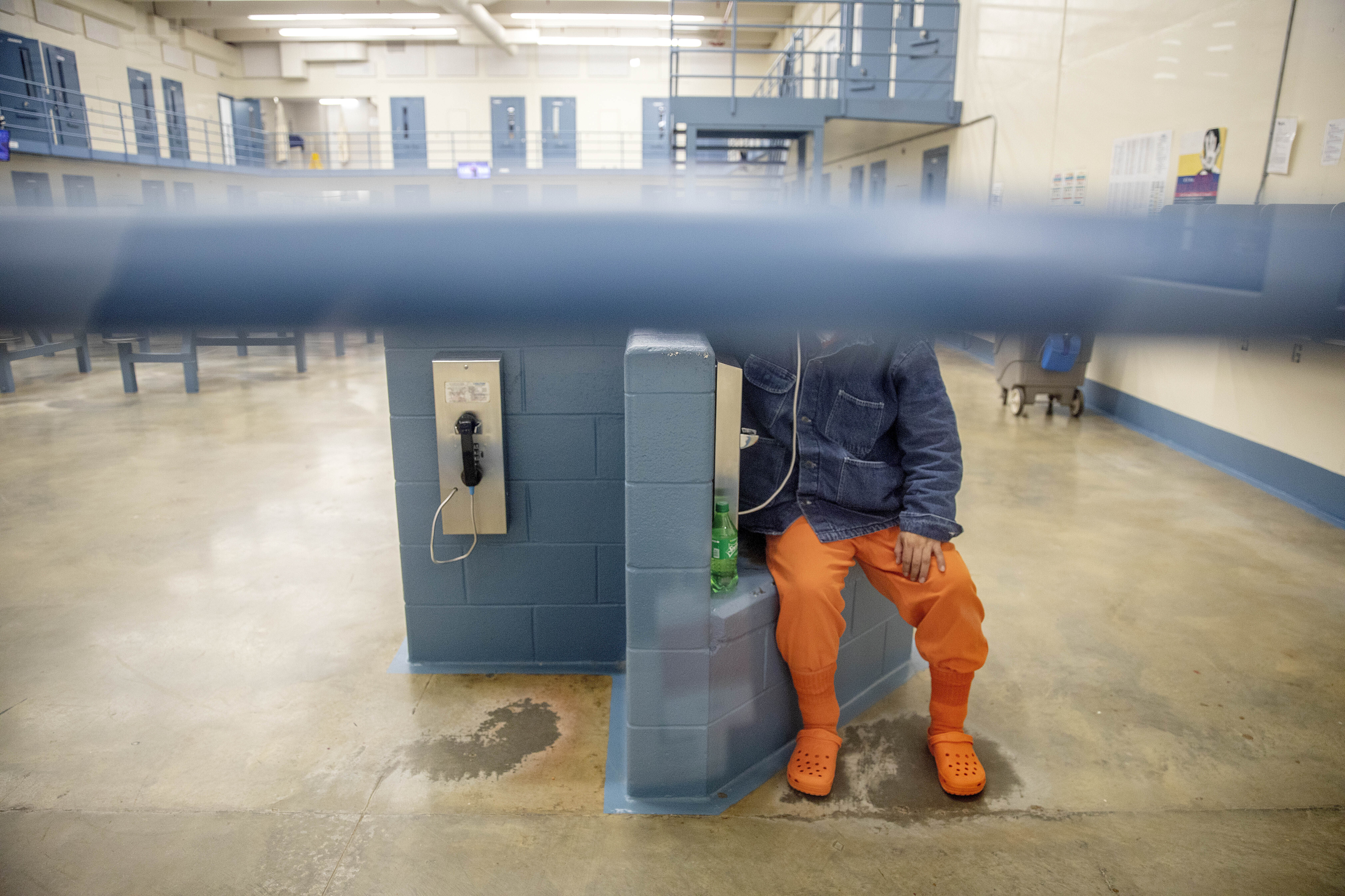 A detainee talks on the phone in his pod at the Stewart Detention Center on Nov. 15, 2019. ICE says it’s working to get those in custody vaccinated. But Amilcar Valencia, executive director of El Refugio, says health concerns in ICE detention centers in Georgia extend beyond COVID-19 and have existed for years. (David Goldman/Associated Press file)