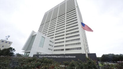 A white high rise building with an American flag in front