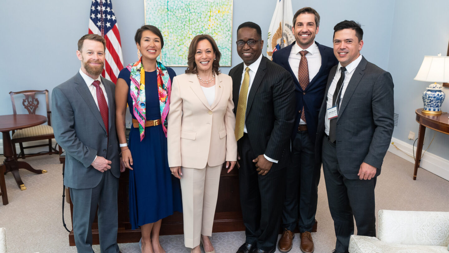 A group of people standing and smiling in the White House