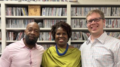 Shawn, Michelle Bolden and Josh Carter stand in front of a bookshelf at WABE.