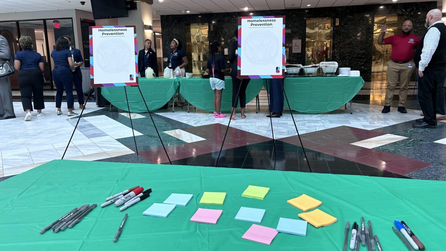 A table with pens and sticky notes in front of empty boards.