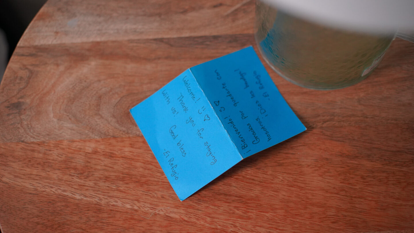 A blue welcome note on a wooden nightstand