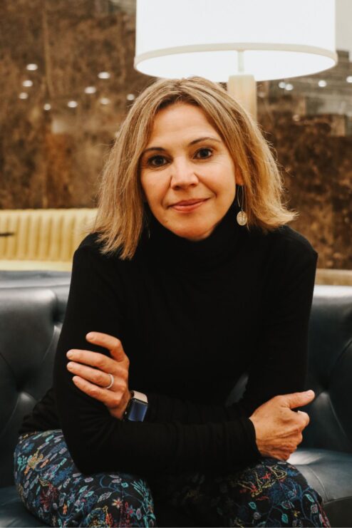 Amanda Watkins seated in a modern lobby setting during an interview