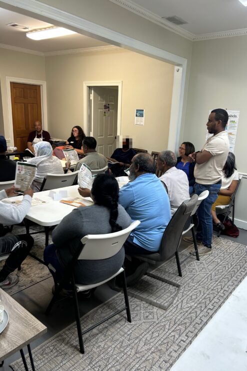 A group of people sit at tables to attend a cooking class