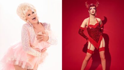 Nina West wearing a sparkling pink costume and blonde wig is next to Suzie Toot in a red costume with horned headpiece, posing against a red backdrop.