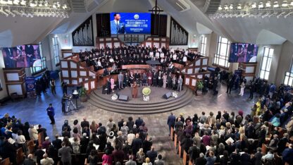 A crowd of people are inside a church during a service