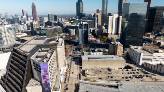Several building in downtown Atlanta are shown on a sunny day with blue skies