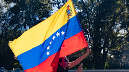 A woman waves Venezuela's flag out her car sunroof.