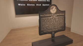 Exhibit wall comparing white and Black newspaper headlines
