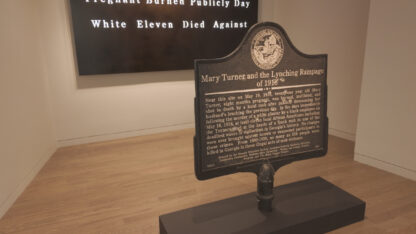 Exhibit wall comparing white and Black newspaper headlines