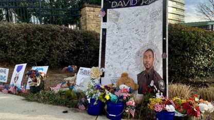 A memorial outside CDC headquarters pays tribute to DeKalb County Police Officer David Rose, killed last summer by a man who had expressed 'discontent' with COVID-19 vaccines. Investigators say the shooter killed Rose before killing himself (WABE/Jess Mador)