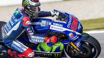 A man riding on a blue Yamaha motorcycle.