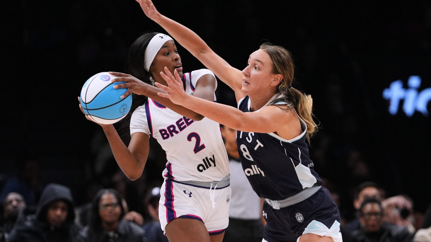 A basketball player defends another player