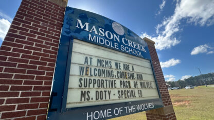 The brick and white and blue sign for Mason Creek Middle School