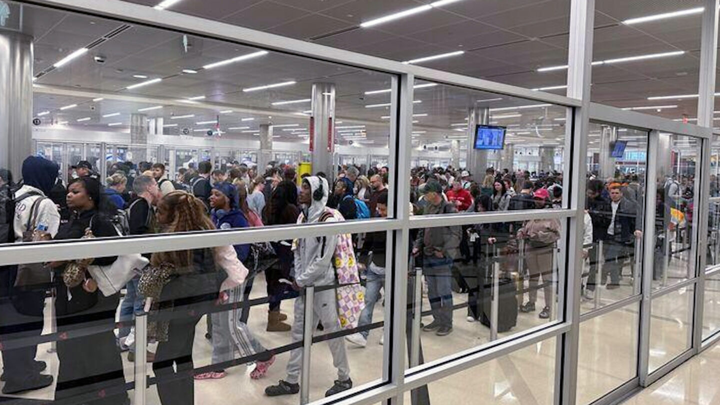 A crowd of hundreds of Travelers wait in line at a security checkpoint at Hartsfield-Jackson Atlanta International Airport