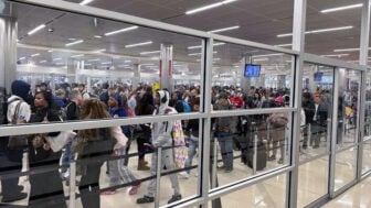 A crowd of hundreds of Travelers wait in line at a security checkpoint at Hartsfield-Jackson Atlanta International Airport