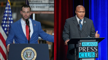 Clay Fuller stands on the left behind a podium and Shawn Harris stands to the right behind a podium.