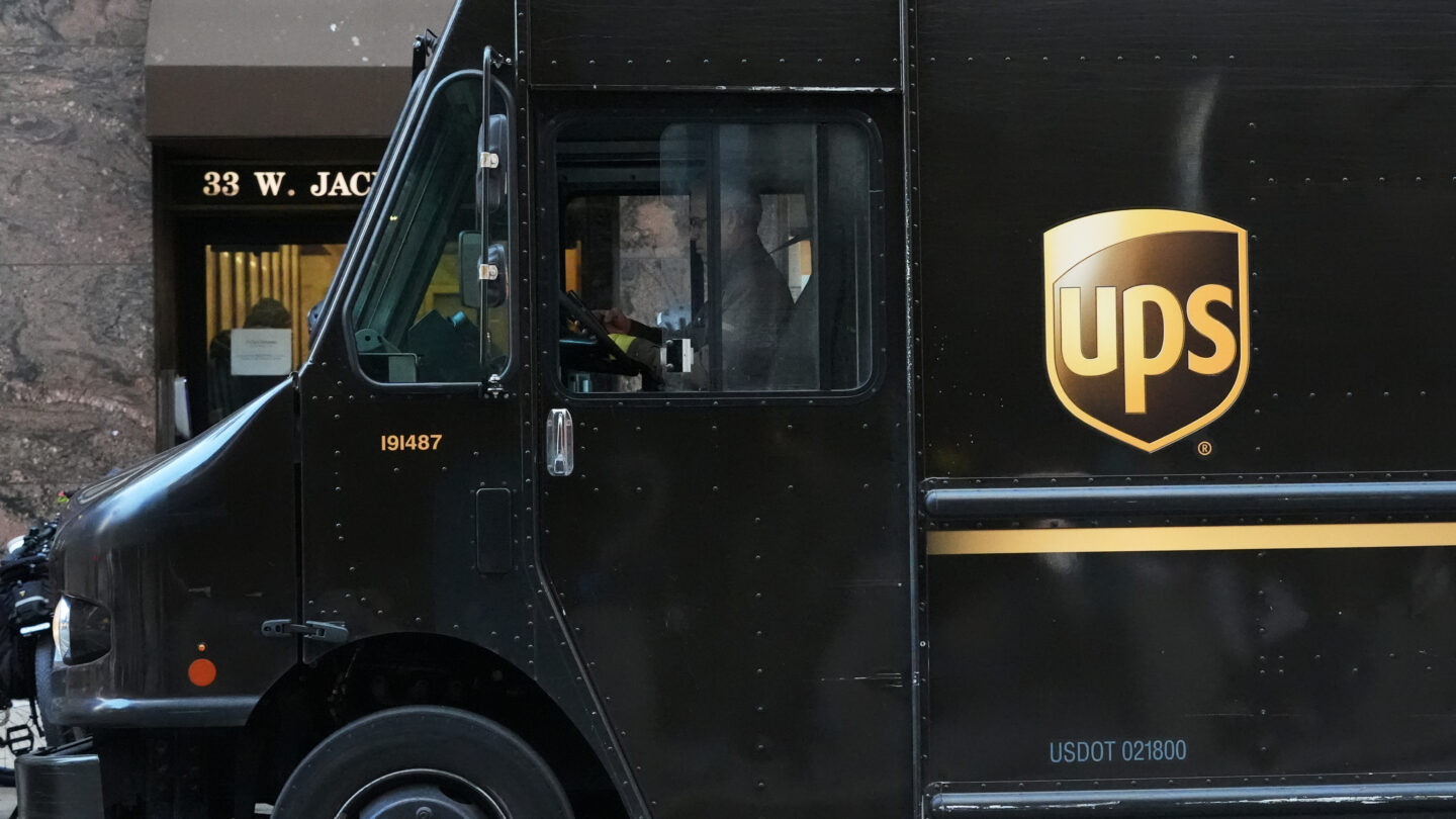 A black UPS truck parks outside of a building