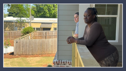 Two people lean out of their balconies to look at the backyard