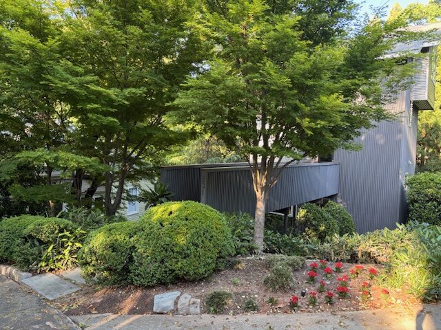 Four story Tree House at 231 DeGress Avenue in Inman Park Atlanta surrounded by lush trees and garden shrubs