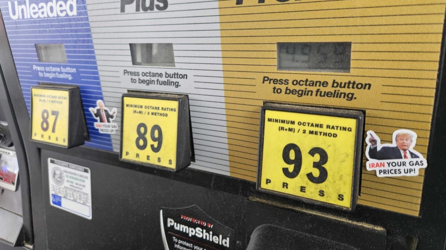 A gas pump is shown with stickers on it showing president donald trump