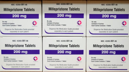 Six boxes of mifepristone stacked on top of each other.