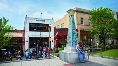 A rendering of a square with restaurants and shops