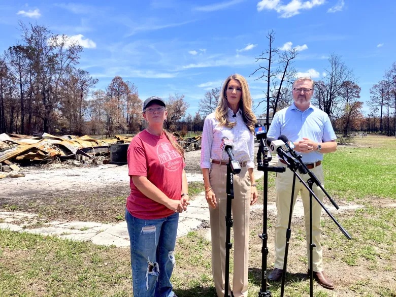 Ginger Hunter, Kelly Leoffler and Chris Snelling stand in front of burned remains of Hunters home.