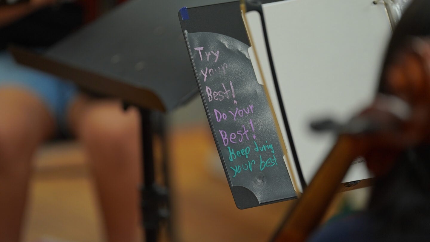 A black binder with Try your best, Do your best, and Keep doing your best written on the flap