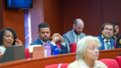 A group of lawmakers sit on a semicircle panel
