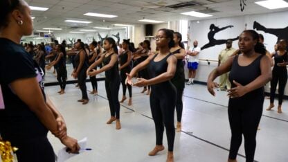 A group of dancers in a room with mirrors.