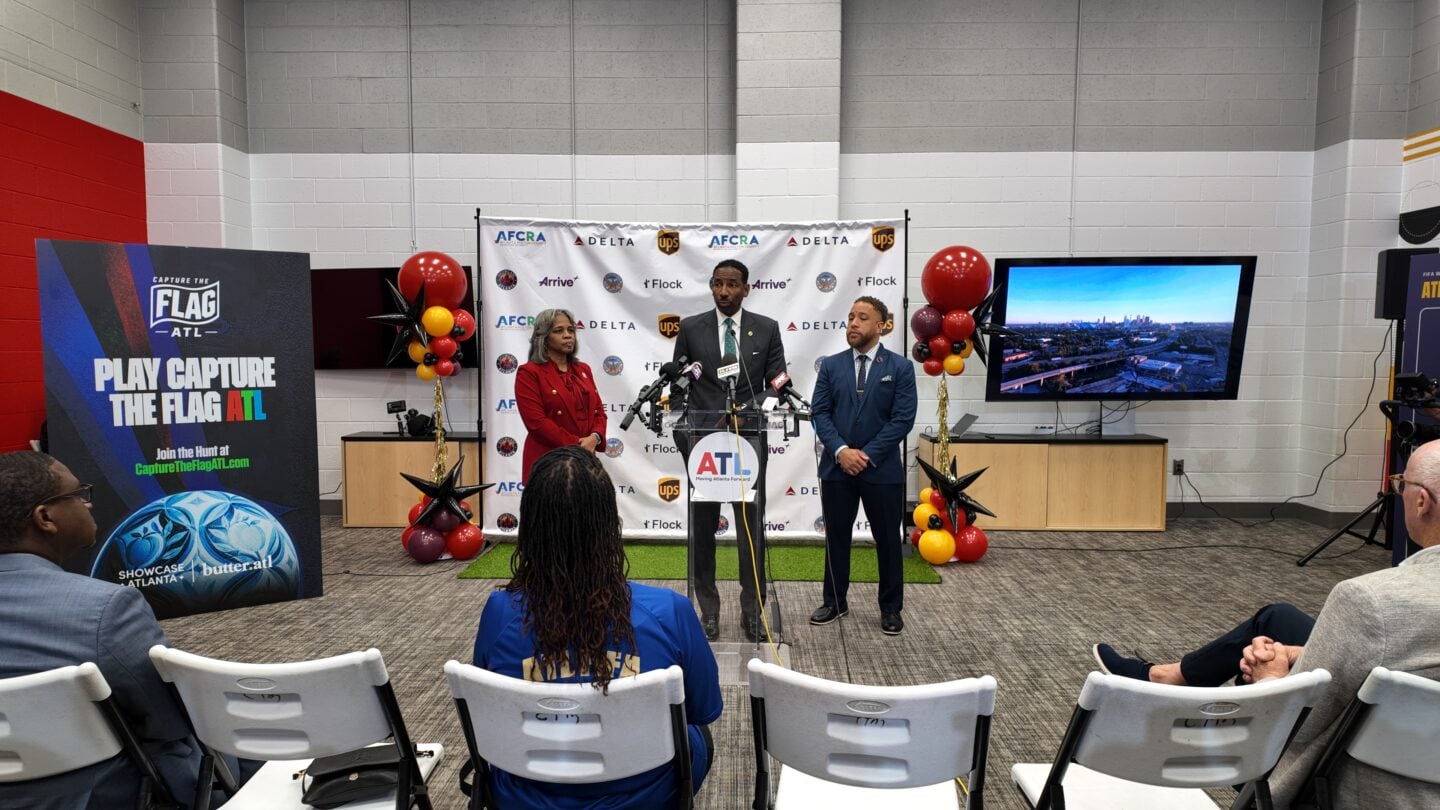 Three city officials stand at a podium.