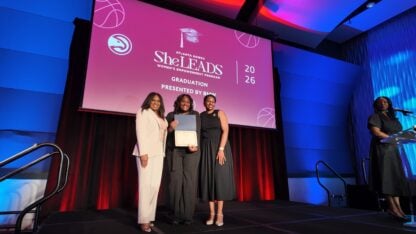 A woman walks on stage and accepts her certificate.