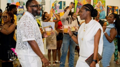 Several people stand in an art gallery