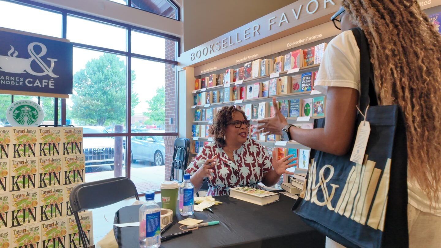 A woman signing books.